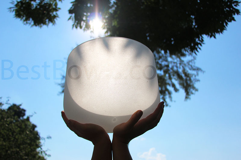 hands holding up a crystal bowl into the light